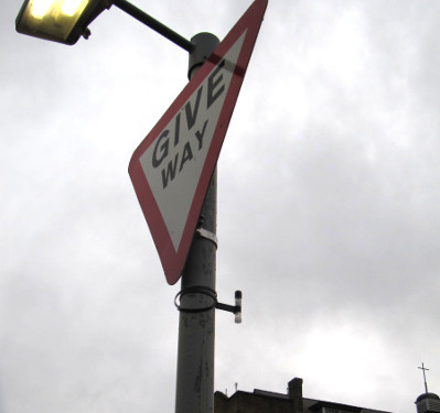 Sign post with with pollution monitor attached to it - see below on the Give Way sign